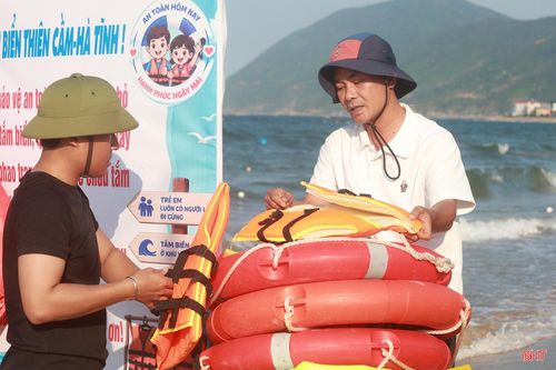 Anh Trần Xuân Vũ sắp xếp áo phao, phao bơi tại điểm cấp phát miễn phí ở bãi biển Thiên Cầm.