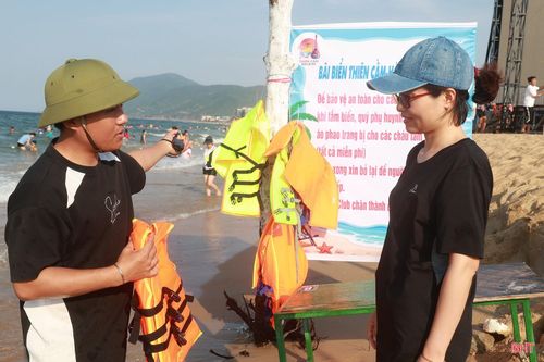 Chị Mạc Thị Thủy, du khách Thành phố Hà Nội tìm hiểu về điểm cấp áo phao, phao bơi miễn phí tại bãi biển Thiên Cầm.