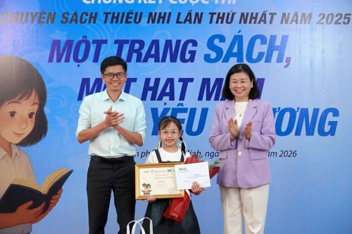 Tổng Biên tập Báo Phụ nữ TPHCM Lý Việt Trung và Phó Giám đốc, Phó Tổng biên tập NXB Tổng Hợp TPHCM Trần Đình Ba trao giải nhất cho em Nguyễn Ngọc Minh Châu, lớp 2A7 Trường Tiểu học Lômônôxốp, Hà Nội. Ảnh: THÚY BÌNH