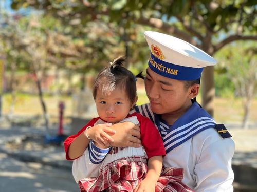 Chiến sĩ trẻ bế em bé của người dân sinh sống trên đảo Đá Tây A