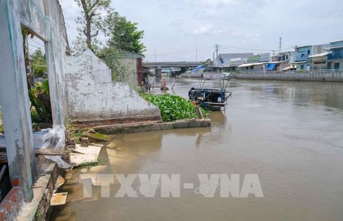 Điểm sạt lở trên kênh Nàng Mau, xã Thạnh Hòa, thành phố Cần Thơ làm một căn nhà bị sụp hoàn toàn xuống sông. Ảnh: Thanh Liêm - TTXVN