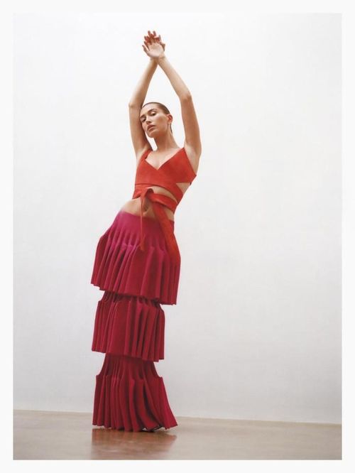 Hailey Bieber diện áo quấn nhung đỏ cổ khoét sâu. Ảnh: Alaïa