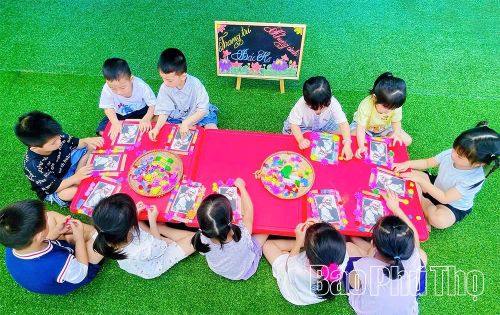 Hình ảnh trẻ tự tay trang trí khung ảnh Bác.