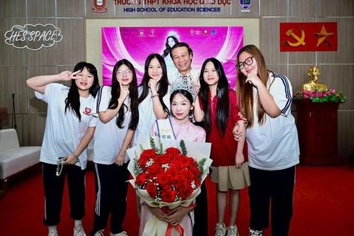 Hoa hậu Hà Linh và NSND Nguyễn Hải chụp ảnh kỷ niệm cùng các bạn học sinh.