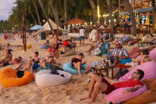  Khách quốc tế ngồi bên bờ biển tại đảo Phú Quốc ngắm hoàng hôn. Ảnh: Quỳnh Danh. 
