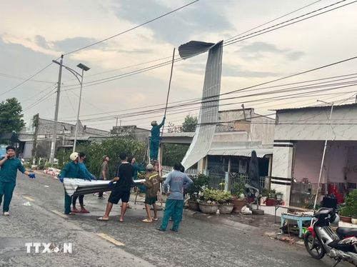 Lực lượng chức năng hỗ trợ người dân khắc phục hậu quả do trận dông lốc gây ra ở xã Long Phú Thuận (tỉnh Đồng Tháp). (Ảnh: TTXVN phát)