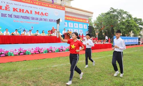  Các vận động viên tiêu biểu của phường Tân An rước đuốc qua lễ đài. 