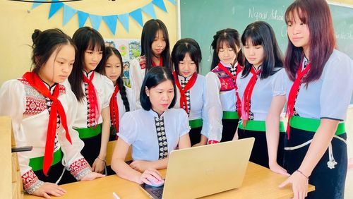 Cô giáo Hoàng Vân Anh cùng học sinh trong trang phục truyền thống.