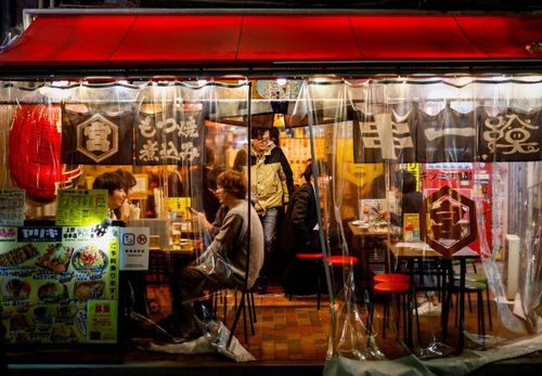  Người dân thưởng thức đồ uống và thức ăn tại một quán rượu izakaya ở khu mua sắm Ameyoko, Tokyo, Nhật Bản, năm 2024. 