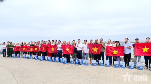  Cán bộ Cảnh sát biển tuyên truyền pháp luật, phát tờ rơi và tặng cờ Tổ quốc cho ngư dân vươn khơi bám biển.