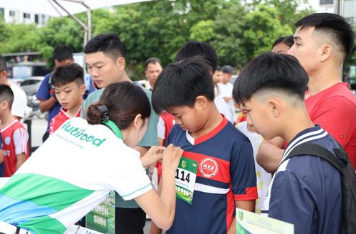 Các thí sinh nhí được gắn bib tại khu vực đăng ký tuyển sinh.
