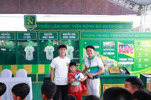 Một cầu thủ nhí hạnh phúc khi được chụp hình với Quốc Việt
