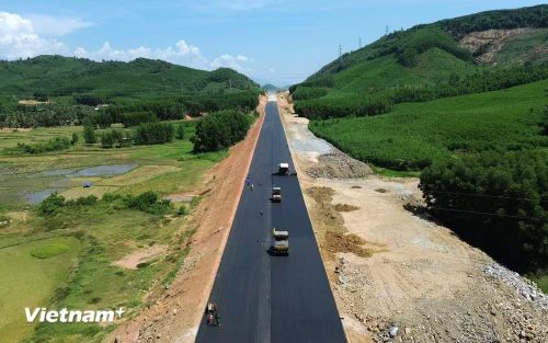 Nhà thầu thi công thảm bêtông nhựa nền đường một tuyến cao tốc. (Ảnh: Khánh Hùng/Vietnam+)