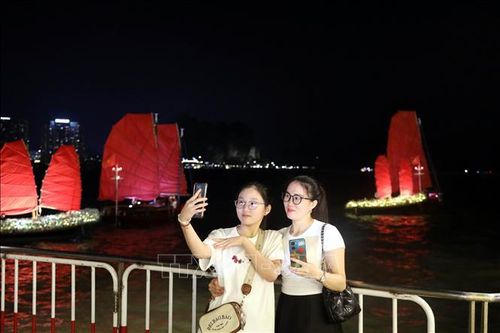 Du khách thích thú checkin cùng những chiếc thuyền buồm đỏ, một sản phẩm du lịch mới của Quảng Ninh. Ảnh: TTXVN