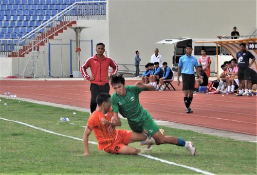 Một pha vào bóng rất mạnh của cầu thủ Quảng Ngãi (áo cam) trước cầu thủ Lâm Đồng (áo xanh) trong một pha bóng bên đường biên