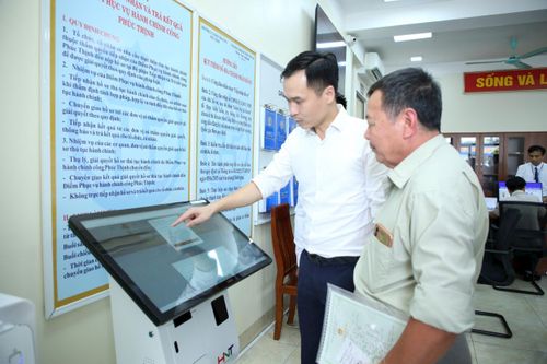 Hướng dẫn người dân làm thủ tục hành chính tại xã Phúc Thịnh, Hà Nội. Ảnh: Phạm Hùng