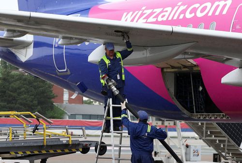 Các công nhân chuẩn bị tiếp nhiên liệu cho máy bay của hãng WizzAir tại sân bay Belgrade. Ảnh: Reuters.