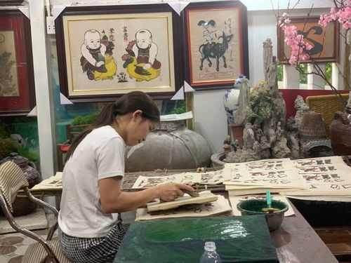 Người nhà gia đình nghệ nhân ưu tú Nguyễn Thị Oanh-nghệ nhân Nguyễn Hữu Hoa đang in tranh Đông Hồ. Ảnh: Thái An.