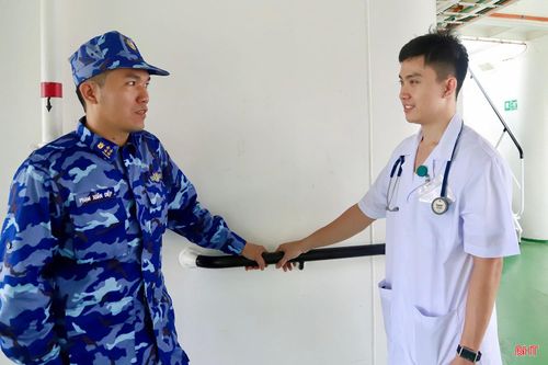 Trung úy, bác sĩ Lê Đắc Quang trò chuyện với cán bộ trên tàu Cảnh sát biển 8004.