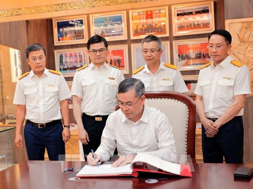 Bộ trưởng Bộ Tài chính Ngô Văn Tuấn viết sổ vàng truyền thống Cục Thuế. Ảnh: Phạm Hậu - TTXVN 