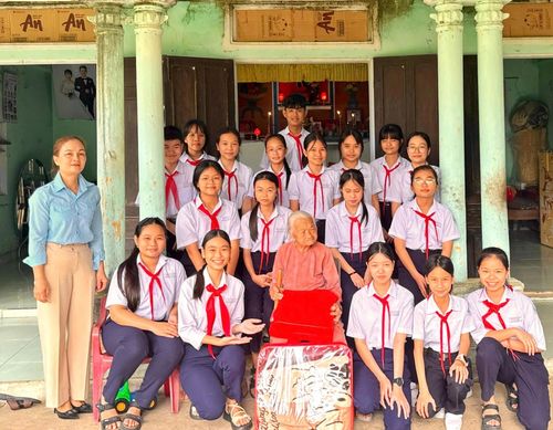 Học sinh, đội viên Trường THCS Đinh Châu (phường Điện Bàn Đông) đến thăm, trò chuyện, tặng quà Bà mẹ Việt Nam anh hùng Kiều Thị Thể. Ảnh: MẾN NGUYỄN