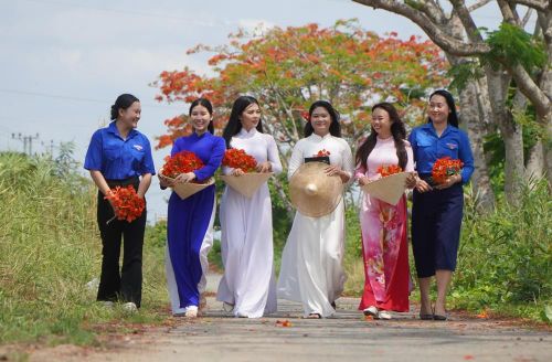 Nhiều bạn trẻ chụp ảnh và lưu giữ thanh xuân với hàng phượng Lấp Vò. Ảnh: Nhựt An - TTXVN