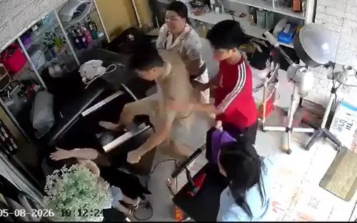 Người phụ nữ đang bế con nhỏ bất ngờ bị nhóm người đánh hội đồng. (Ảnh cắt từ clip)