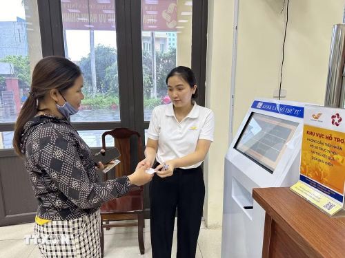 Cán bộ phường Vĩnh Phúc, tỉnh Phú Thọ hỗ trợ người dân đăng ký, lấy số khi làm thủ tục hành chính. (Ảnh: Nguyễn Thảo/TTXVN)