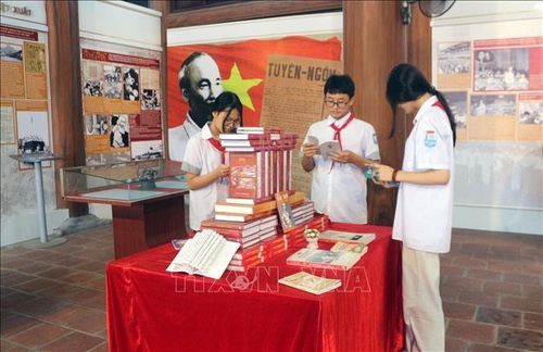 Các em học sinh đọc sách về Bác tại khu lưu niệm.