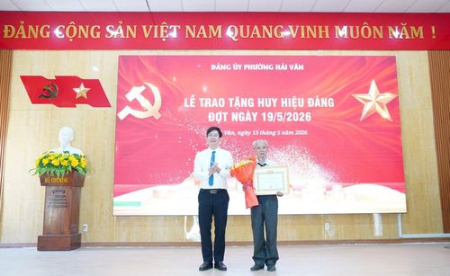 Bí thư Đảng ủy phường Hải Vân Hoàng Thanh Hòa trao Huy hiệu 60 năm tuổi Đảng cho đảng viên. Ảnh: KIM HIẾU