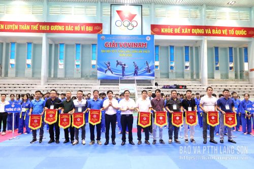 Đại diện Ban Tổ chức trao cờ lưu niệm cho đại diện các đoàn VĐV