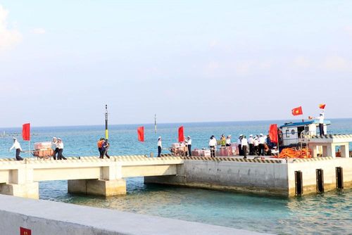 Quốc kỳ tung bay tại khu vực cầu cảng Đá Lớn B khi Đoàn công tác số 12 đến thăm đảo dịp cuối tháng 4/2026. Ảnh: Tiến Lực - TTXVN