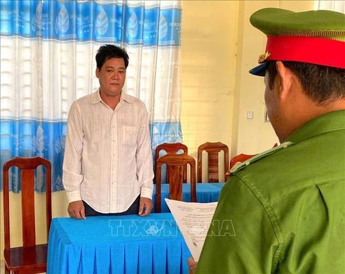 Công an tỉnh An Giang tống đạt các quyết định khởi tố vụ án, khởi tố bị can và lệnh cấm đi khỏi nơi cư trú đối với Đỗ Văn Quý. Ảnh: TTXVN phát