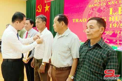 Lãnh đạo xã Chiềng Mung trao huy hiệu cho các đảng viên.