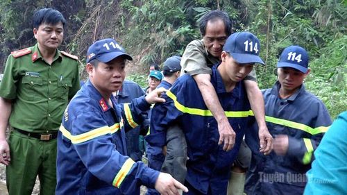 Lực lượng tìm kiếm thay nhau cõng ông Tá vượt hơn 2 km đường núi để về nhà. Bài, ảnh: Văn Long