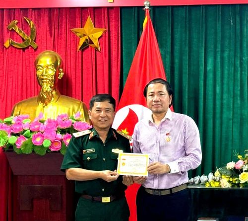 Trung tướng Trần Tấn Hùng, Phó Chủ tịch Hội Hỗ trợ gia đình liệt sĩ Việt Nam trao Quyết định và gắn Kỷ niệm chương, ghi nhận sự hỗ trợ của ông Trần Việt Anh và Câu lạc bộ thiện nguyện Ấm tình yêu thương trong công tác tri ân liệt sĩ. Ảnh: Mai Hoa