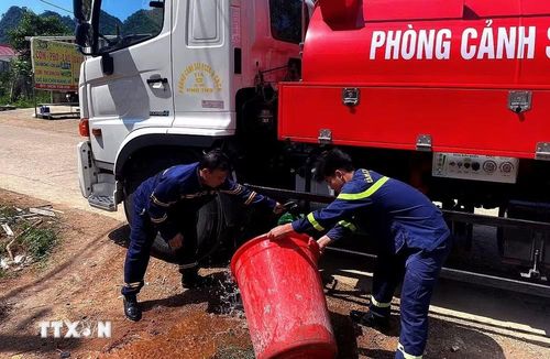 Cảnh sát phòng cháy, chữa cháy và cứu nạn, cứu hộ sử dụng xe chuyên dụng chở nước sinh hoạt cho bà con xã Pà Cò. (Ảnh: Thanh Hải/TTXVN)