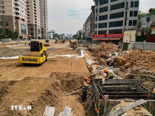 Công nhân và máy móc được huy động để thi công hạng mục hạ tầng kỹ thuật trên tuyến đường Vành đai 2,5.(Ảnh: Lê Đông/TTXVN)