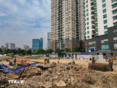 Công nhân và máy móc được huy động để thi công hạng mục hạ tầng kỹ thuật trên tuyến đường Vành đai 2,5.(Ảnh: Lê Đông/TTXVN)