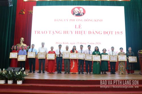 Đồng chí Phó Bí thư Thường trực Đảng ủy phường Đông Kinh trao huy hiệu tặng các đảng viên