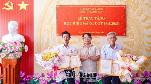 Đồng chí Trương Văn Ty, Phó Bí thư Thường trực Đảng ủy xã Đất Mũi, trao Huy hiệu 30, 45 năm tuổi Đảng cho các đồng chí Huỳnh Thành Công và Quách Văn Thịch.