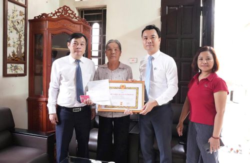 Đồng chí Hoàng Anh Tú, Phó Bí thư thường trực Đảng ủy xã Bát Tràng trao Huy hiệu Đảng tặng đảng viên lão thành. Ảnh: Phương Lộc