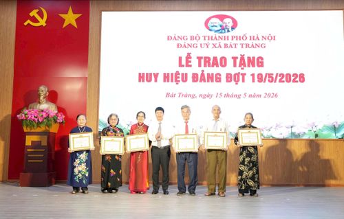 Đồng chí Nguyễn Văn Quyến, Bí thư Đảng ủy, Chủ tịch HĐND xã Bát Tràng trao Huy hiệu Đảng tặng các đảng viên. Ảnh: Phương Lộc