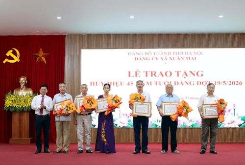 Các đồng chí Thường trực Đảng ủy, Ban Thường vụ Đảng ủy xã trao Huy hiệu Đảng tặng các đảng viên. Ảnh: Thu Hiền