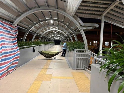Bảo vệ mắc võng trên cầu bộ hành metro số 1 để ngăn người dân qua lại khi hết giờ tàu metro chạy. Ảnh: Mạng xã hội