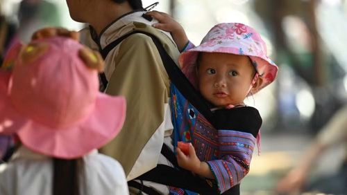 Em bé người Mông theo mẹ đến hội.