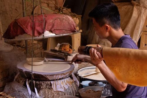 Người thợ khéo léo thực hiện công đoạn tráng bánh từ bột gạo, đòi hỏi sự tỉ mỉ để từng lớp bánh đạt độ mỏng và mịn đều cho sản phẩm bánh đa nướng. (Ảnh: Hà Anh/TTXVN phát)