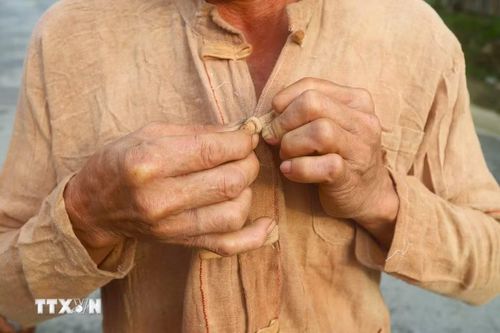 Trên áo truyền thống của người đàn ông Ơ Đu có 1 hàng khuy áo, nhưng không có cúc mà sử dụng các nút khóa để cài khi mặc áo. (Ảnh: Xuân Tiến/TTXVN)