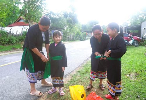 Phụ nữ dân tộc Ơ Đu chỉnh sửa trang phục truyền thống cho con cháu tham gia dự lễ hội đốn tiếng sấm đầu năm của dân tộc Ơ Đu. (Ảnh: Xuân Tiến/TTXVN)