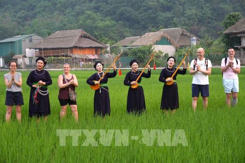Du khách quốc tế trải nghiệm không gian văn hóa hát Then, đàn tính của đồng bào Tày tại thôn Tha, phường Hà Giang 1, tỉnh Tuyên Quang. Ảnh: Minh Tâm-TTXVN